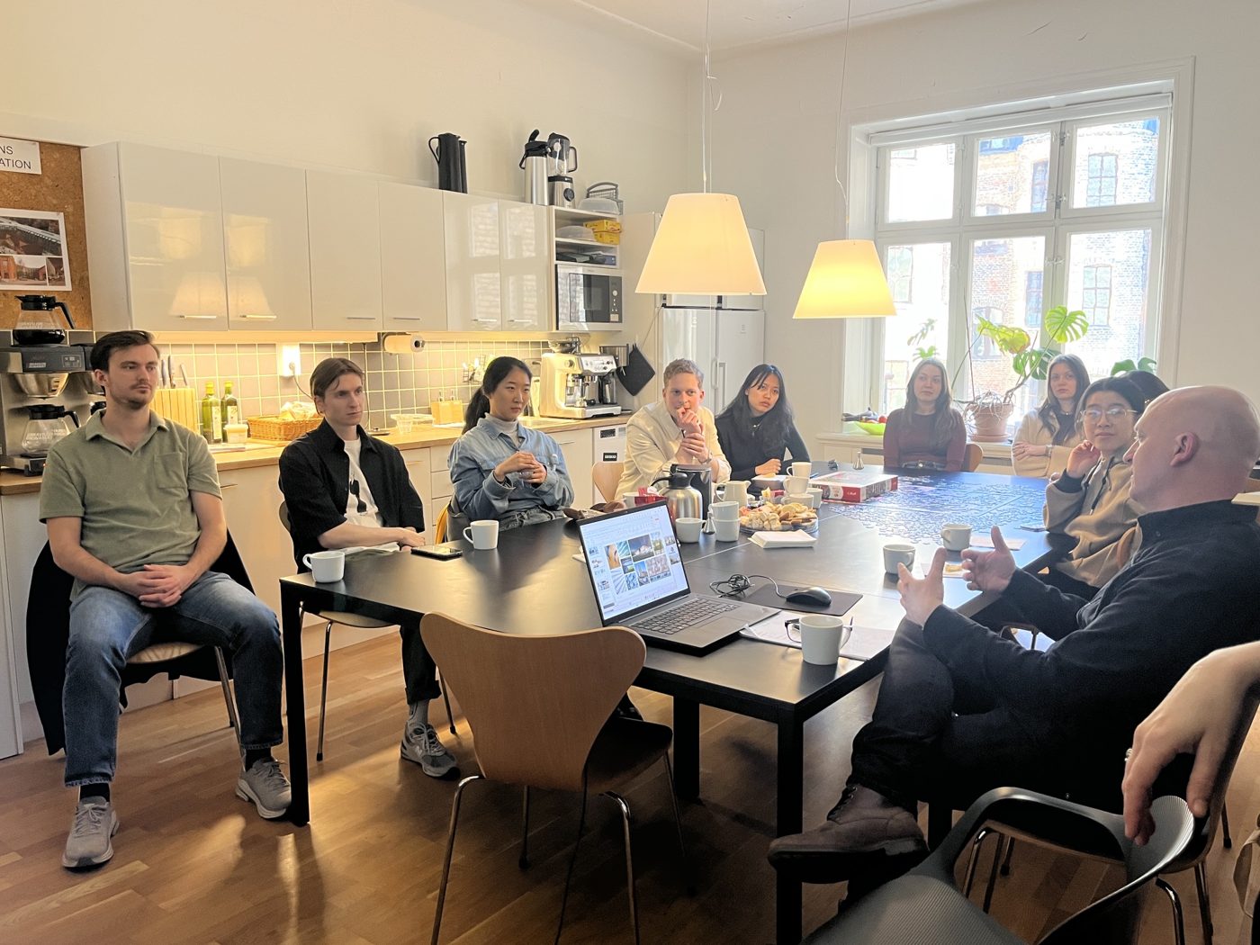 Students around a table listening to an architect from FOJAB